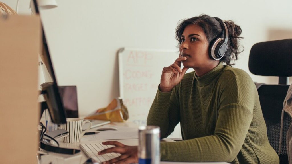 Woman with headset sitting at desk with computer