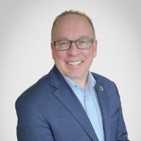 Man with glasses in blue suit.
